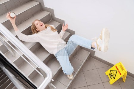Young woman fell down on wet steps in stairway. Trauma concept