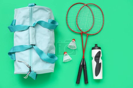 Photo for Sport bag, badminton racket and water bottle on green background - Royalty Free Image