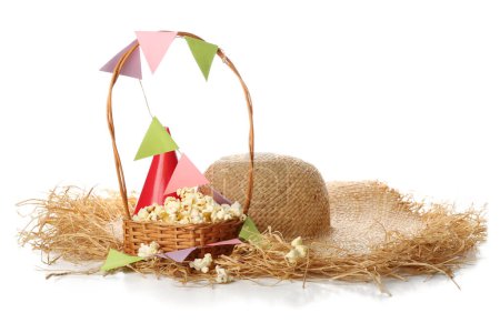 Basket of popcorn, paper flags and straw hat on white background. Festa Junina (June Festival) celebration