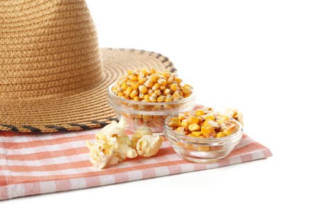 Bowls of corn with hat and napkin on white background, closeup. Festa Junina (June Festival) celebration