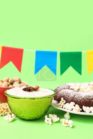 Traditional food with flags for Festa Junina (June Festival) on green background