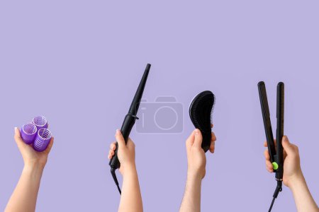 Téléchargez les photos : Beaucoup de mains avec différentes fournitures de coiffure sur fond lilas - en image libre de droit