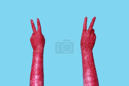 Téléchargez les photos : Femme avec les mains peintes montrant geste de victoire sur fond de couleur, gros plan - en image libre de droit