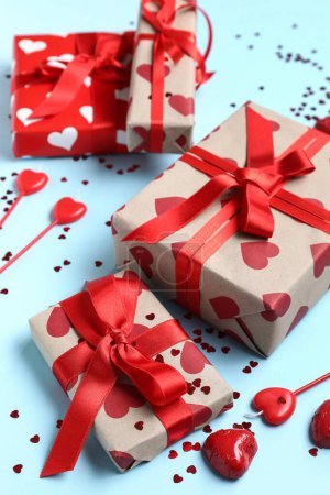Schöne Geschenkschachteln mit Kerzen und Konfetti auf blauem Hintergrund. Valentinstag-Feier