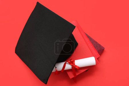 Photo for Graduation hat with diploma and notebooks on red background - Royalty Free Image