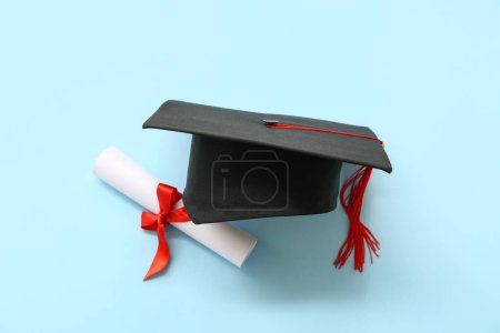 Photo for Graduation hat and diploma on blue background - Royalty Free Image