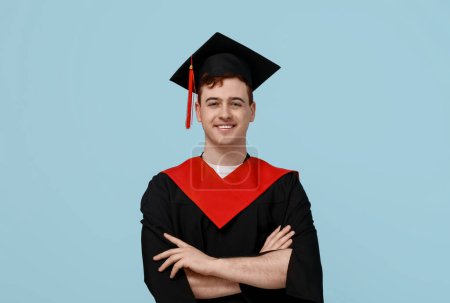 Photo for Happy male graduating student on blue background - Royalty Free Image