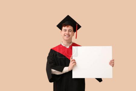 Photo for Male graduating student with blank poster on beige background - Royalty Free Image