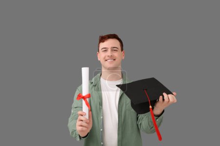 Photo for Male student with mortar board and diploma on grey background - Royalty Free Image