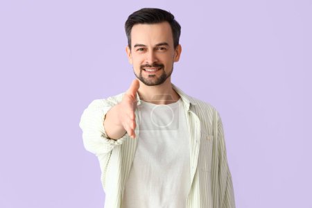 Photo for Handsome man reaching out for handshake on lilac background - Royalty Free Image