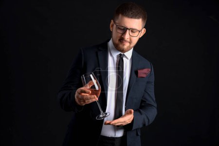 Photo for Young sommelier with glass of wine on black background - Royalty Free Image