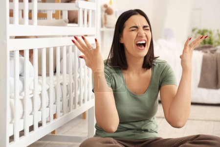 Jeune femme en colère avec son bébé dans la crèche souffrant de dépression postnatale à la maison