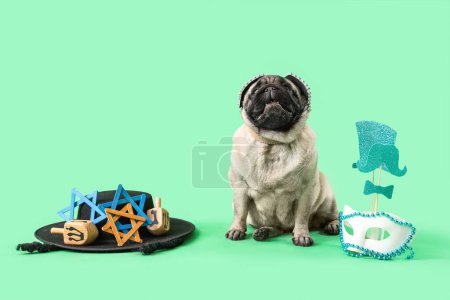 Téléchargez les photos : Chien chiot mignon avec biscuits Hamantaschen et décor pour des vacances Pourim sur fond vert - en image libre de droit
