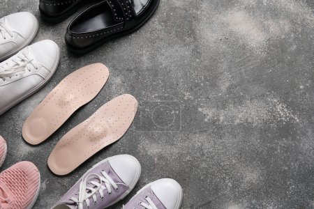 Photo for Different female shoes and pair of orthopedic insoles on grunge background - Royalty Free Image