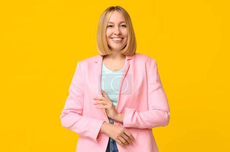 Happy young woman with bob hairstyle on yellow background
