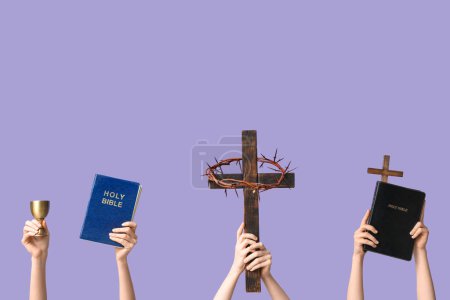 Photo for Female hands with Holy Bibles, wooden crosses and cup on lilac background. Good Friday concept - Royalty Free Image