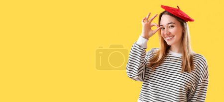 Foto de Joven francesa mostrando OK sobre fondo amarillo con espacio para texto - Imagen libre de derechos