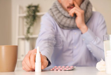 Téléchargez les photos : Homme d'affaires malade avec des gouttes nasales sur la table au bureau, gros plan - en image libre de droit