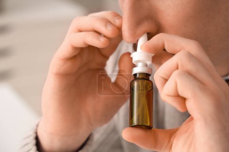 Téléchargez les photos : Homme d'affaires malade utilisant des gouttes nasales au bureau, gros plan - en image libre de droit