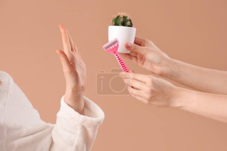 Photo for Beautiful young woman rejecting shaving razor on brown background - Royalty Free Image