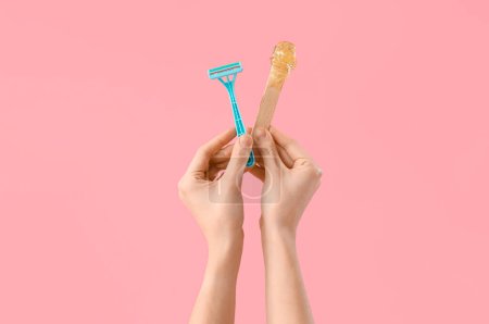 Photo for Female hands holding spatula with sugaring paste and razor on pink background - Royalty Free Image