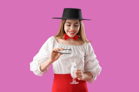 Female bartender with tongs and ice cubes on purple background