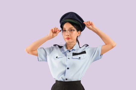 Young Asian postwoman wearing glasses on lilac background