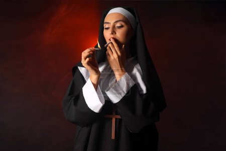 Freche Nonne zündet Zigarette auf dunklem Hintergrund an