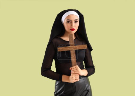 Téléchargez les photos : Nonne sexy avec croix sur fond vert - en image libre de droit