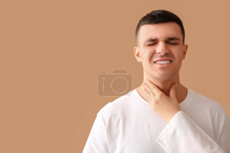 Endocrinologist examining thyroid gland of young man on beige background, closeup