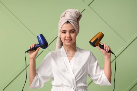 Photo for Beautiful young happy woman with hair dryers on green background - Royalty Free Image