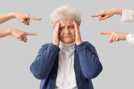 Menschen zeigen auf gestresste Seniorin auf hellem Hintergrund. Anschuldigungskonzept