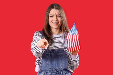 Junge Frau mit USA-Fahne zeigt auf den Betrachter auf rotem Hintergrund. Anschuldigungskonzept