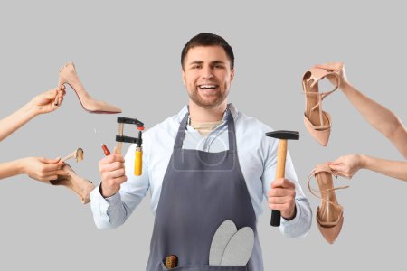 Male shoemaker with tools and broken shoes on light background