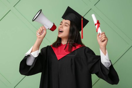Photo for Female graduating student with diploma and megaphone on green wooden background - Royalty Free Image