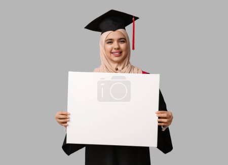 Photo for Happy Muslim female graduating student with blank poster on white background - Royalty Free Image