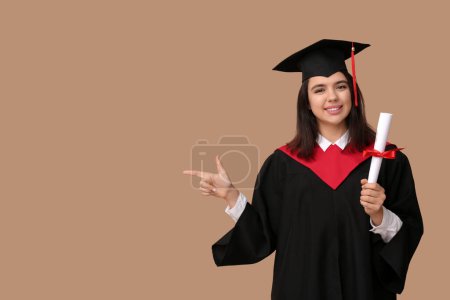 Photo for Happy female graduating student with diploma pointing at something on beige background - Royalty Free Image