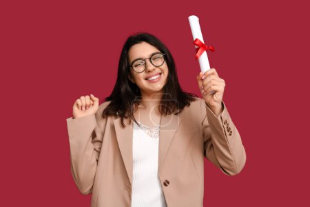 Photo for Happy smiling female student with diploma on red background - Royalty Free Image