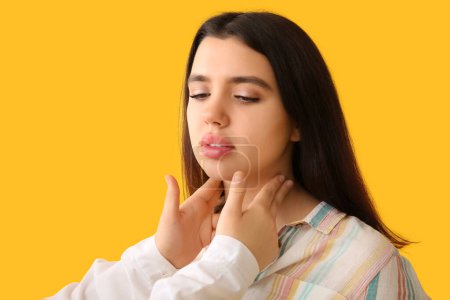 Photo for Endocrinologist examining thyroid gland of young woman on yellow background - Royalty Free Image