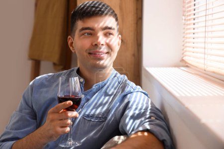 Téléchargez les photos : Jeune homme avec un verre de vin rouge à la maison, gros plan - en image libre de droit
