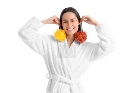 Young woman in bathrobe with loofahs on white background
