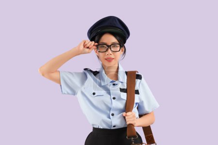 Junge asiatische Postbotin trägt Brille auf fliederfarbenem Hintergrund