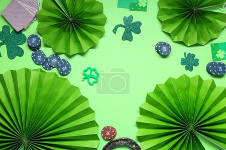 Poker chips, paper fans and clovers on green background. St. Patrick's Day celebration