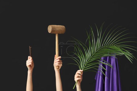Photo for Female hands with wooden mallet, palm leaf and purple fabric on dark background. Good Friday concept - Royalty Free Image