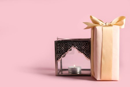 Geschenkkarton mit muslimischer Lampe zum Ramadan auf rosa Hintergrund