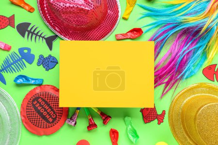 Blank card with wig, hats and party decor on green background. April Fools Day celebration