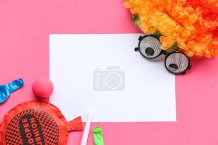 Blank card with whoopee cushion, funny glasses and clown wig on pink background. April Fools Day celebration