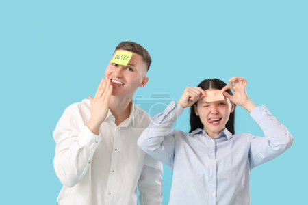 Photo for Business people with sticky papers on their foreheads against blue background. April Fools' Day celebration - Royalty Free Image