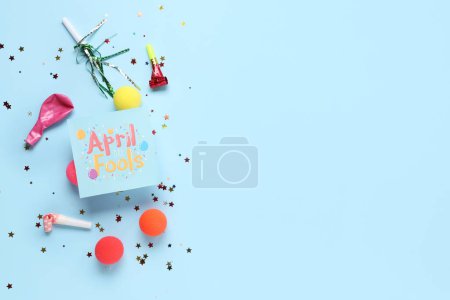 Festive postcard for April Fools Day with party whistles, clown noses and sequins on blue background