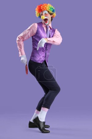 Foto de Retrato de payaso con cojín de whoopee sobre fondo lila. Broma del día del tonto de abril - Imagen libre de derechos